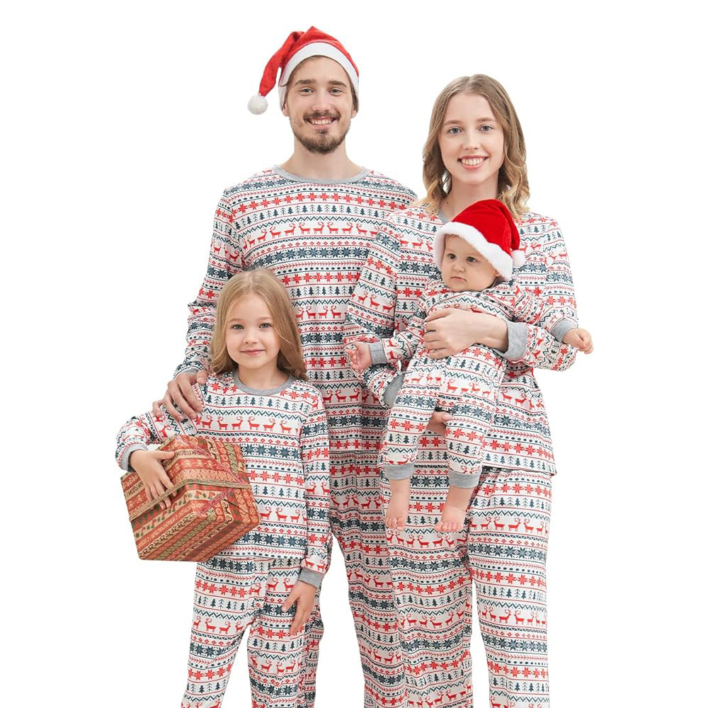 Dad and mum with their two kids all wearing the same long matching PJs, wearing Christmas hats and holding a present