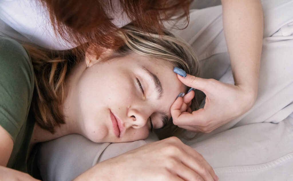 Mother taking care of sick sleeping daughter teenager