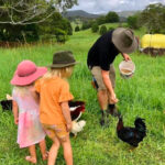 Young family enjoying Hosanna Farmstay by feeding chickens