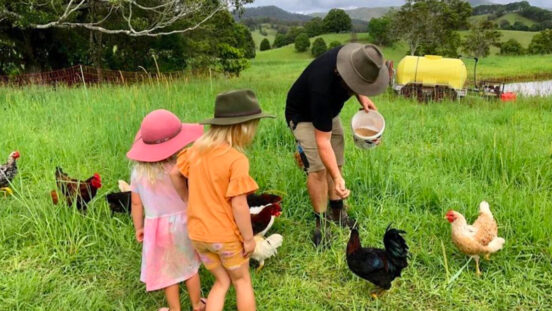 Young family enjoying Hosanna Farmstay by feeding chickens