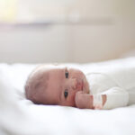 A newborn laying on a bed at the maternity ward.