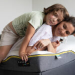 Smiling mother and child lay on Teddy box mattress