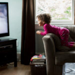 Mixed race girl watching television.