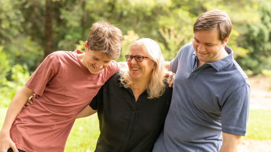 Mother hugging her teenage sons Australia