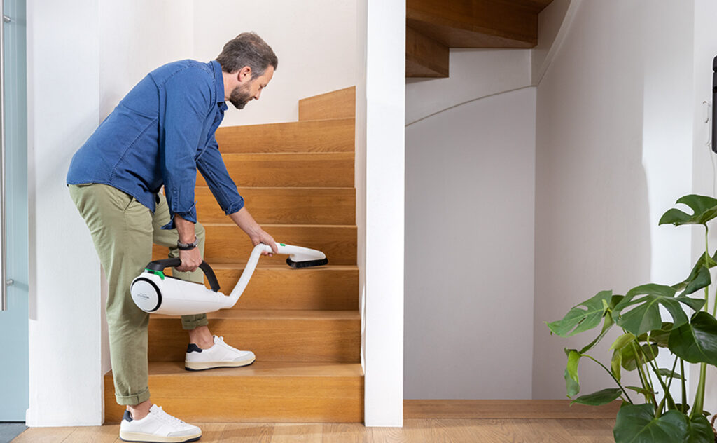 Man uses Thermomix Kobold Vac mop attachment to clean stairs