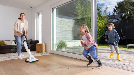 Mother uses Thermomix Kobold vac mop while children run dirt inside