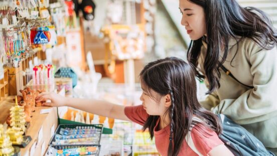 Asian girl and mother shopping for back to school stationery