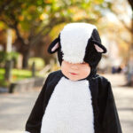 Baby boy in costume standing on footpath in NYC