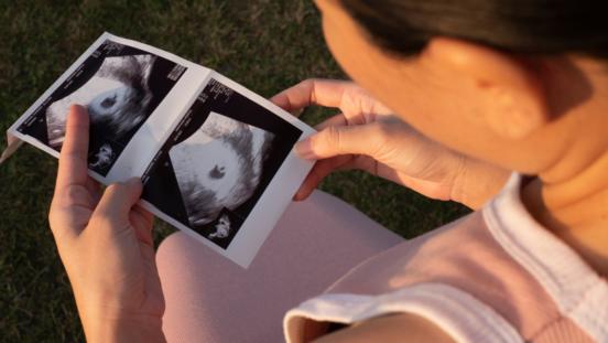 Side view of a woman looking at an early pregnancy scan