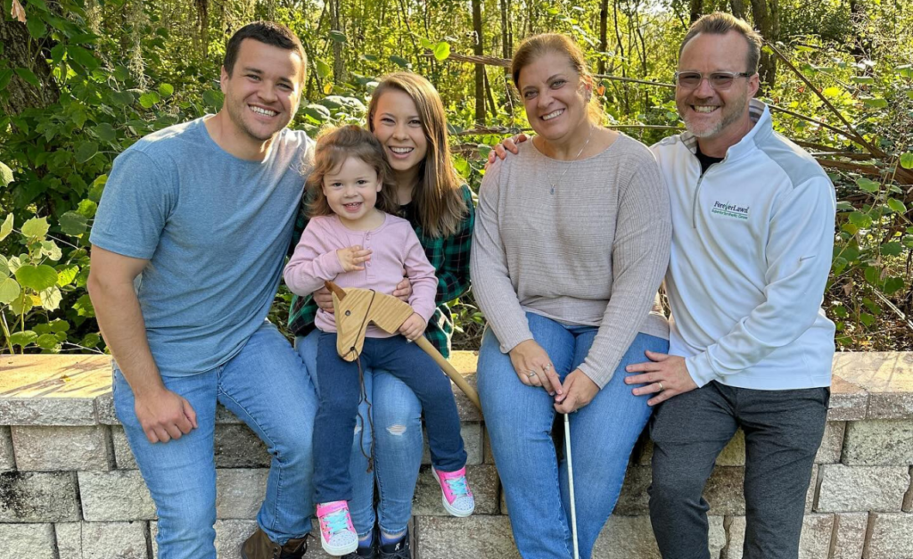 Bindi, Grace and Chandler sitting on a wall with Chandler's parents