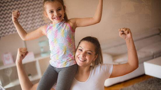 Just strong. Mother and daughter at home flexing their muscles