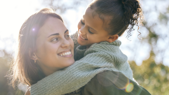 Smiling mum looks back at the daughter who is on her back