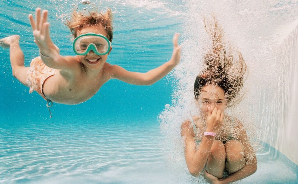 Girl and Boy Underwater in Swimming Pool