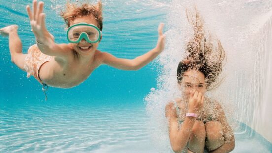 Girl and Boy Underwater in Swimming Pool