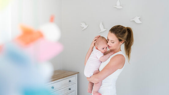 Mother and baby in nursery room with bird imagery on wall