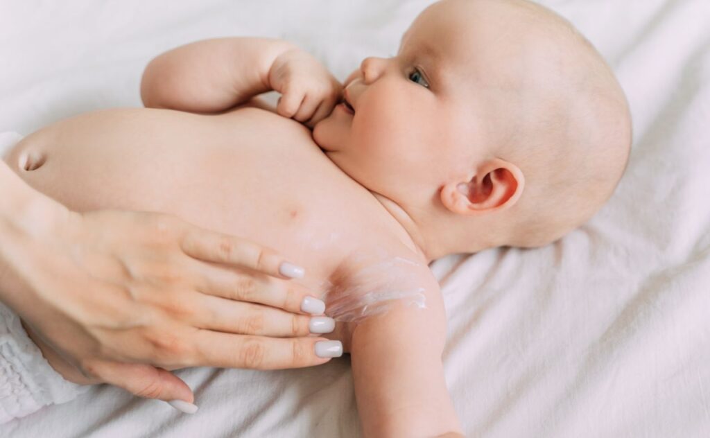 Sensitive skin: Mother putting lotion on baby's skin