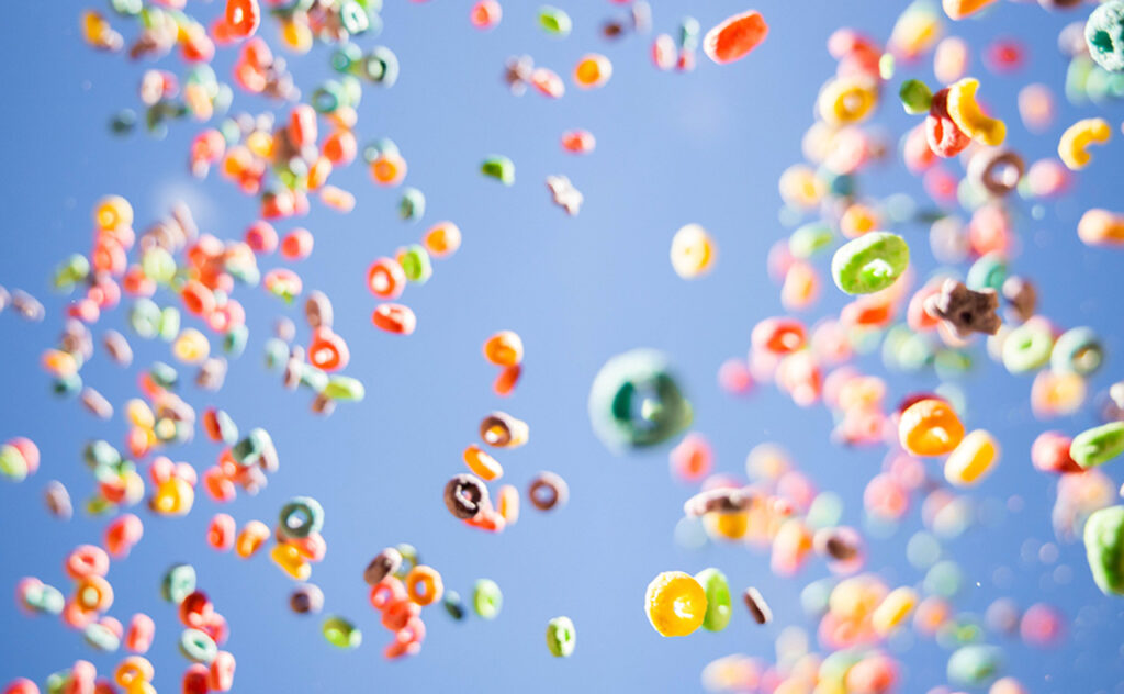 Colorful fruit loops cereals levitating in the sky in a beautiful visual effect