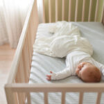 High angle view of baby boy sleeping in crib at home