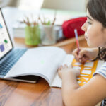 Little girl studying on laptop computer