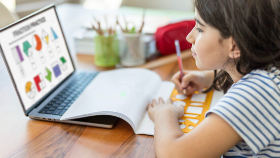 Little girl studying on laptop computer