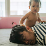 Morning Mood Asian baby wake up early before daddy and playful on the bed