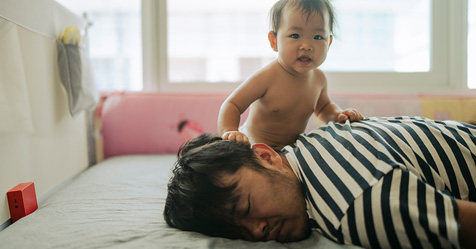 Morning Mood Asian baby wake up early before daddy and playful on the bed