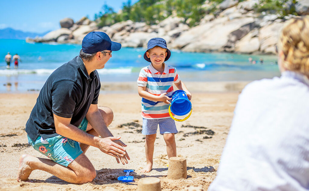 Father and young son playing on Sand at Magnetic Island Townsville