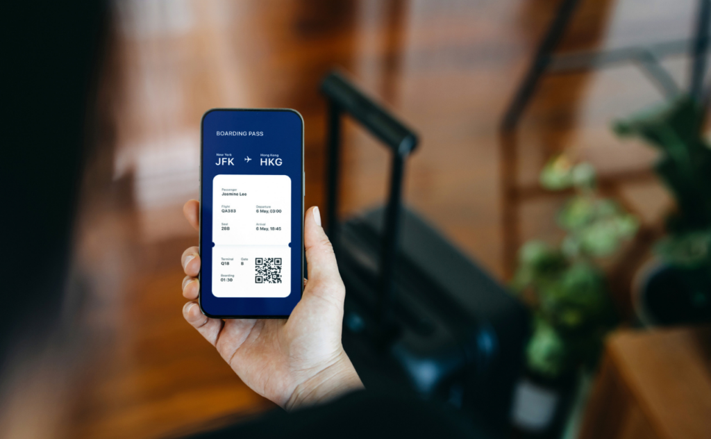 Hand holding a phone that shows a flight boarding pass