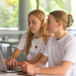 Young women university students studying together in a library