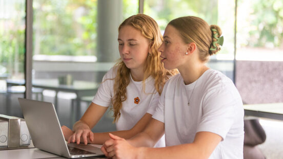 Young women university students studying together in a library