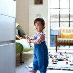 Little girl in denim dungarees playing at home, leisure, childhood, innocence