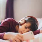 Girl resting in her bedroom is surfing social media for viral videos