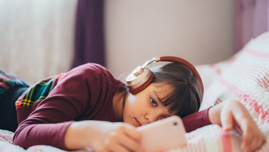 Girl resting in her bedroom is surfing social media for viral videos