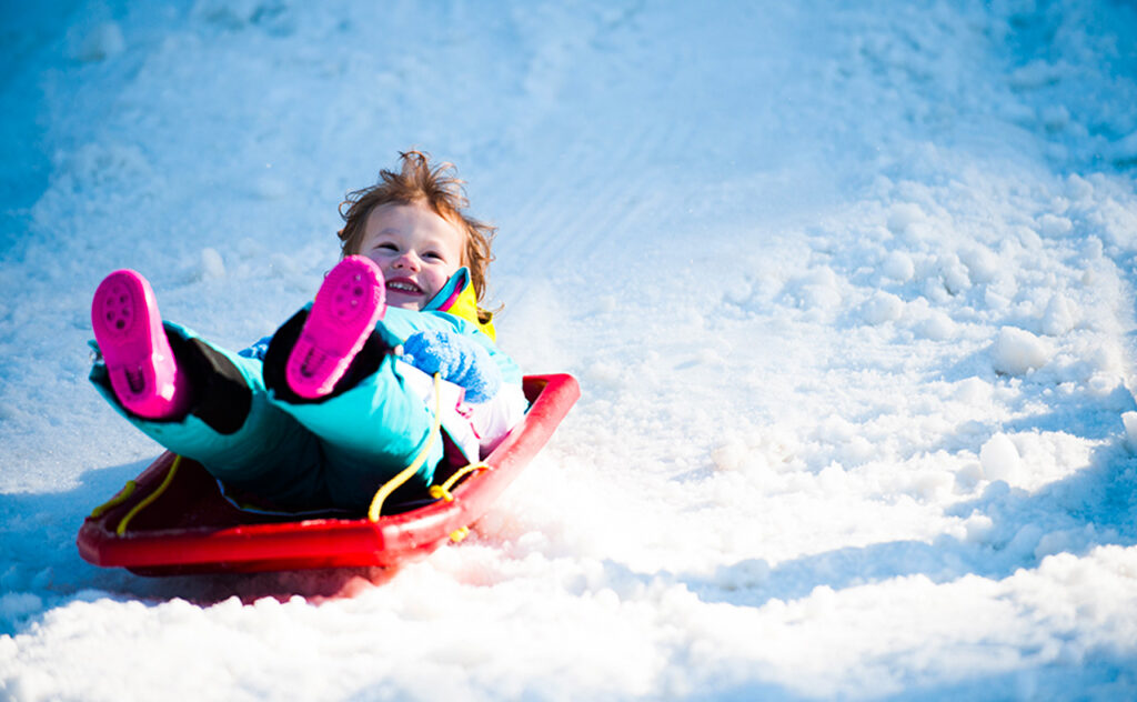 small child tobogganing at Corin forest canberra