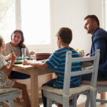 Family At Home In Eating Meal Together
