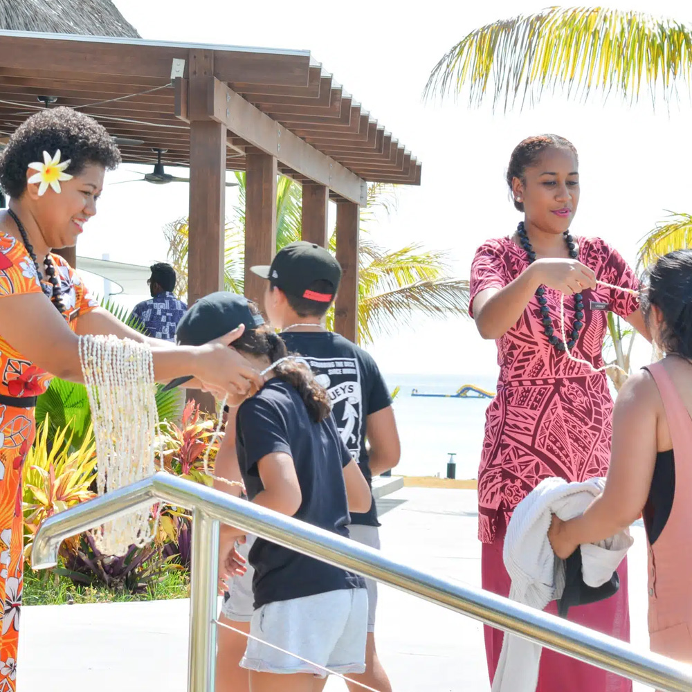 Locals welcome guest with shell necklaces at Plantation Island Resort