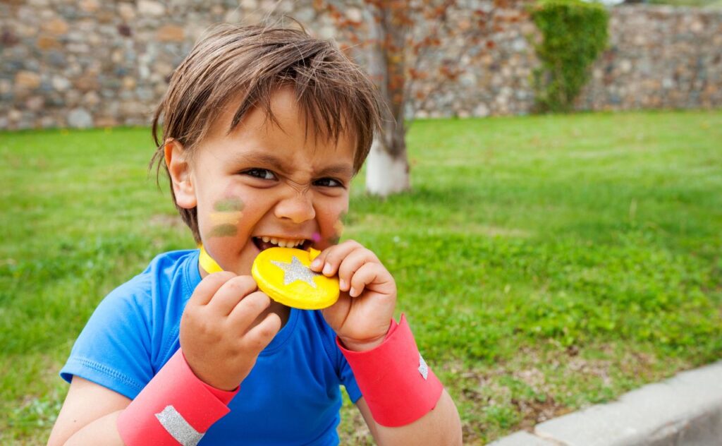 Little boy biting on medal, Olympic sports