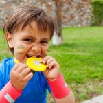 Little boy biting on medal, Olympic sports
