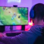 Gaming mental health: Teen boy gaming and looking at computer monitor