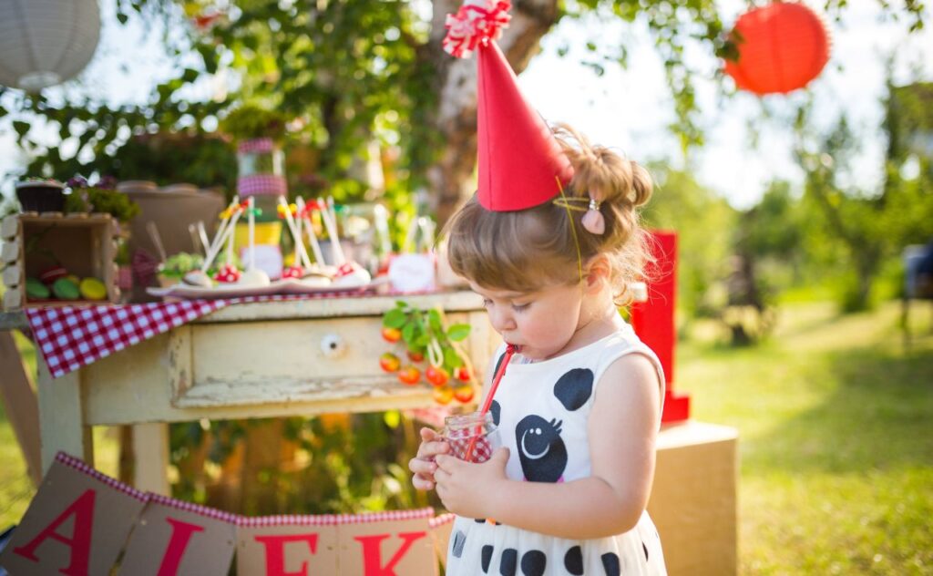 Toddler wearing party hat ready for her party in the park