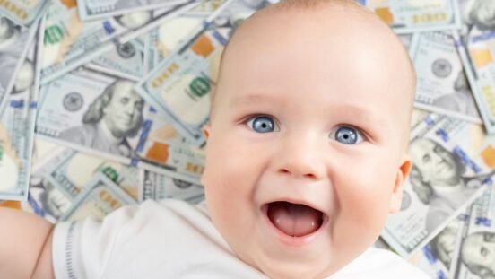 Rich baby names: Blue-eyed baby laying on dollar bills
