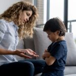 Not time-out, time-in: Boy having a tantrum at home and mother trying to talk to him