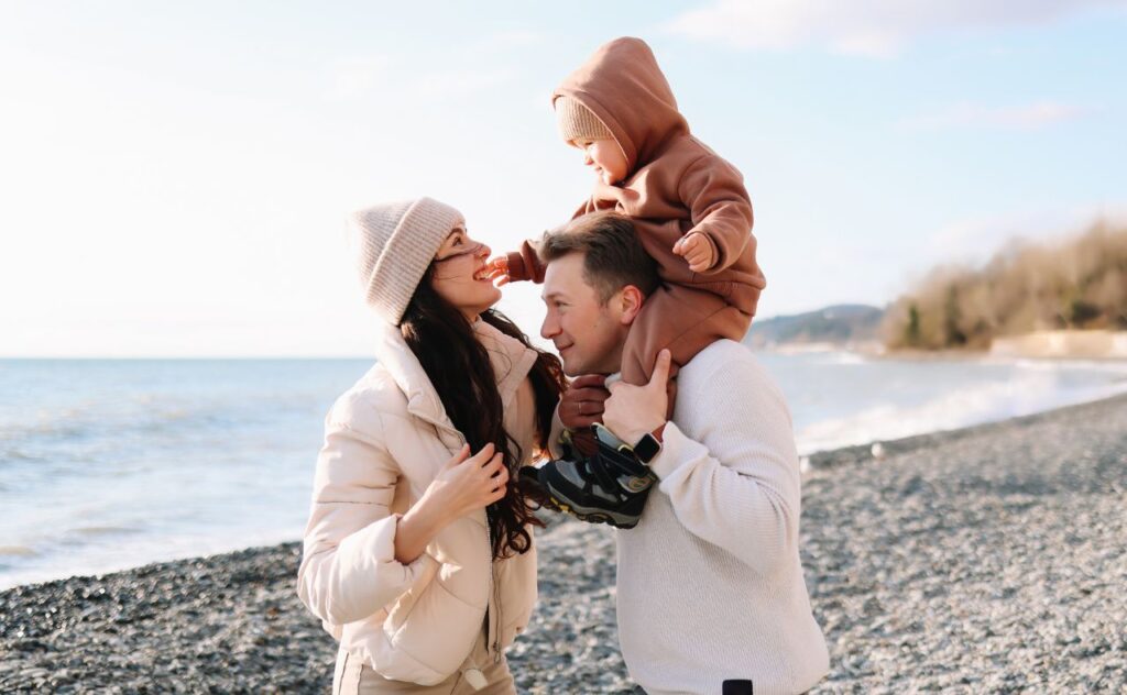 Parents and toddler at the beach in winter