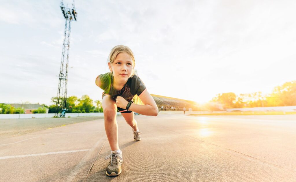Kids running: Pre teen girl gets ready to run