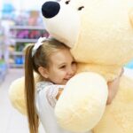 Happy girl hugging a large plush toy in a shop