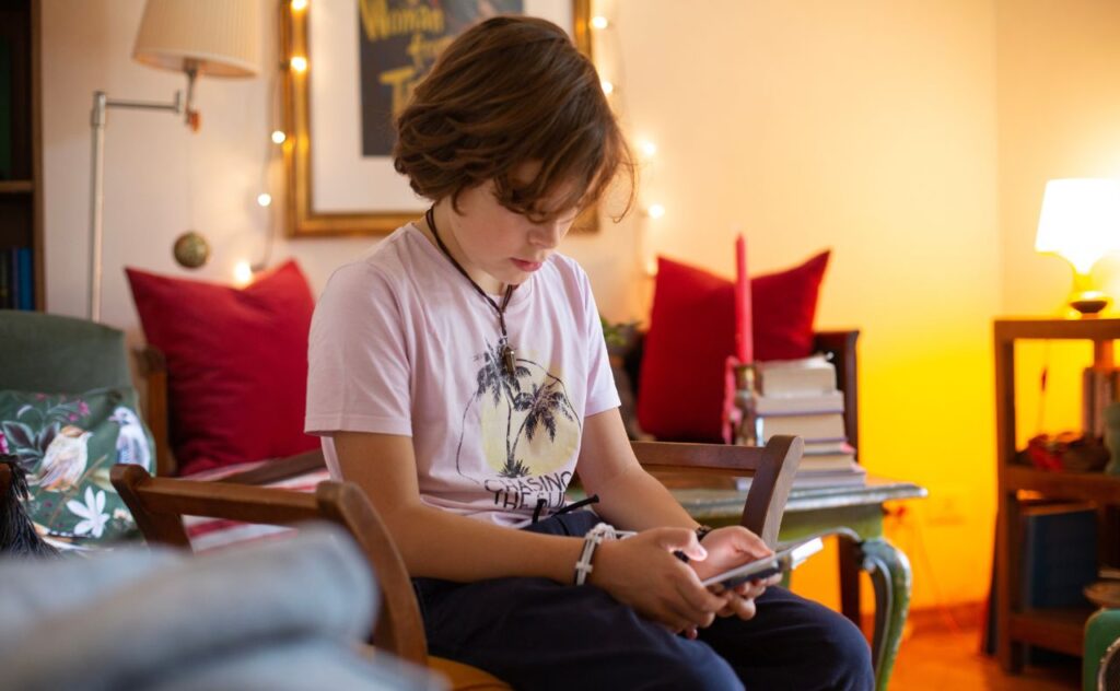 Parenting in a digital age: Boy using smart phone at home