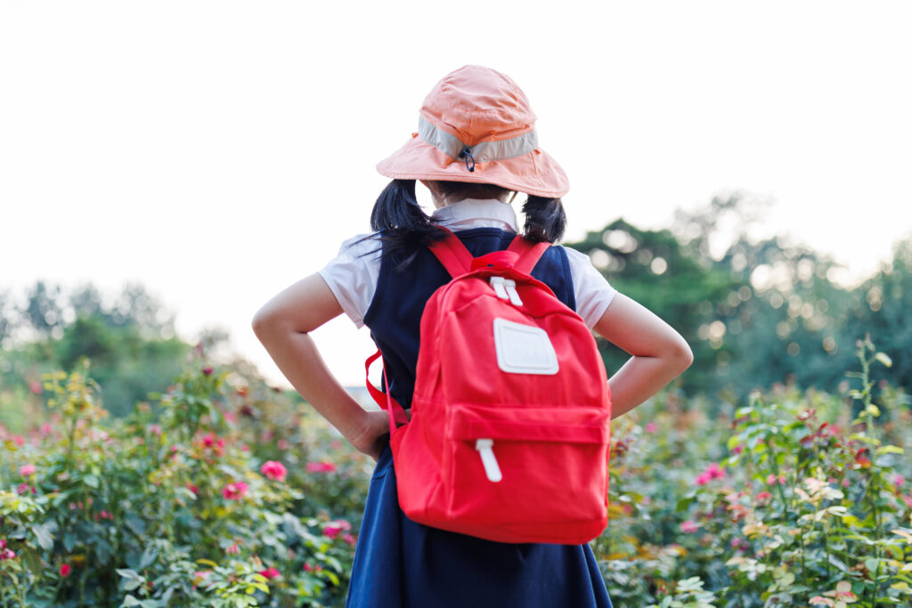 little girl with backpack and hat