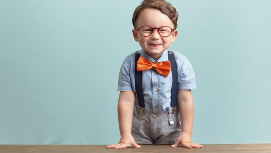 Old fashioned boy names: A smiling little boy wearing a orange bowtie and glasses