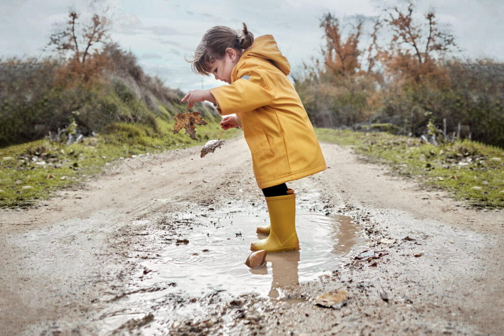 little one splashing in muddy puddle