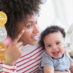 Best skincare products for mums: Mother holding baby and applying moisturising cream